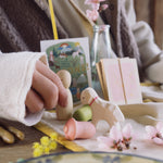 A close up of a child's hand playing with the Nin from the Grapat and Ostheimer collaboration  Handmade Seasonal Play Set Hello Spring.