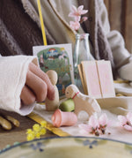 A close up of a child's hand playing with the Nin from the Grapat and Ostheimer collaboration  Handmade Seasonal Play Set Hello Spring.