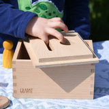 Child placing the lid upside down on the Grapat permanence box. 