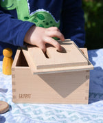 Child placing the lid upside down on the Grapat permanence box. 