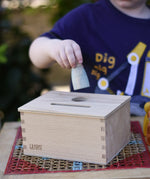 Grapat object permanence box, child posting a blue animal Nins through the circular shaped hole.