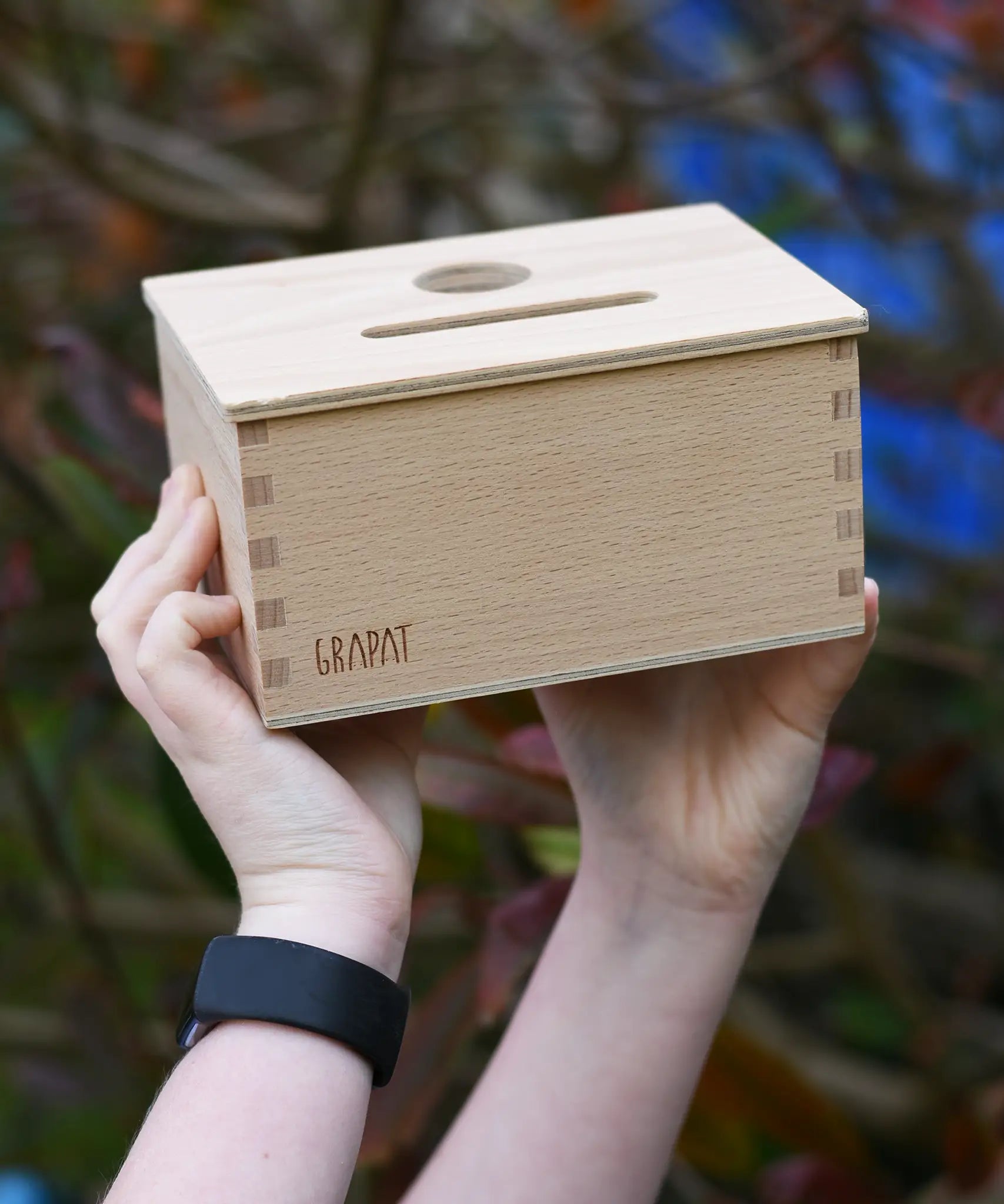 Grapat object permanence box shown in a child's hands.