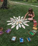 A child playing with the Grapat petals wooden platform.  A set of 24 wooden petals. These platform bases are perfect for use with Grapat mandala pieces. These wooden petals are part of a huge range of open ended wooden toys from Grapat available here at Babipur.