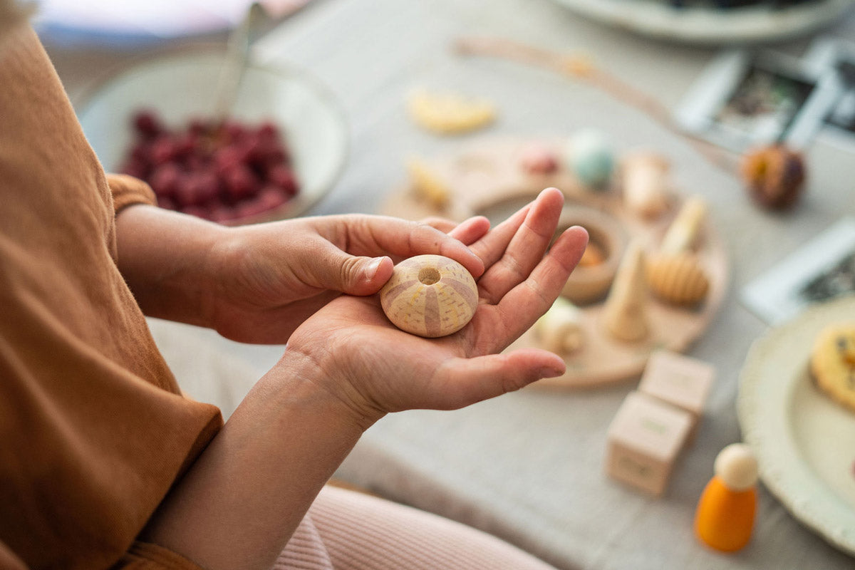 Close up of a childs hands holding a piece from the Grapat eco-friendly wild wonders toy set