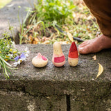 Close up of the Grapat yay wooden toy set on a stone wall next to a childs feet