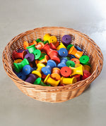 Grapat 36 Wooden Spools shown placed in a wicker basket. These wooden toys are part of a wide range of open ended toys available at Babipur.  