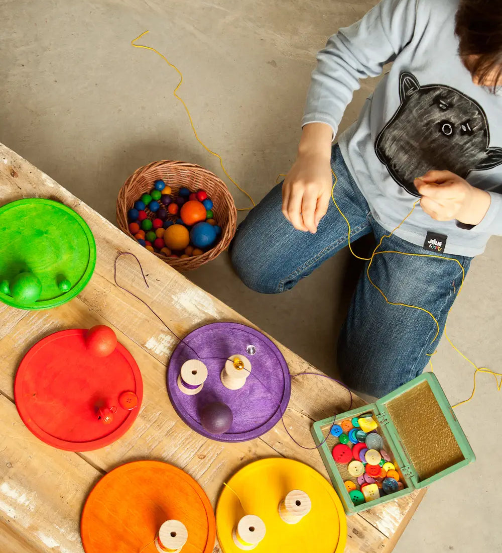 Child's creative play using the Grapat wooden rainbow dishes and various small items