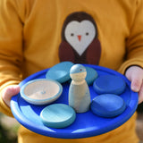 Blue Grapat rainbow dish in a child's hands with blue coloured toys placed on it. 