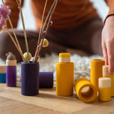 Close up of child's hands playing with the Grapat wooden Lo toy set on a wooden floor