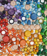 A variety of coloured handcrafted Grapat wooden loose pieces laid in a decorative flatlay