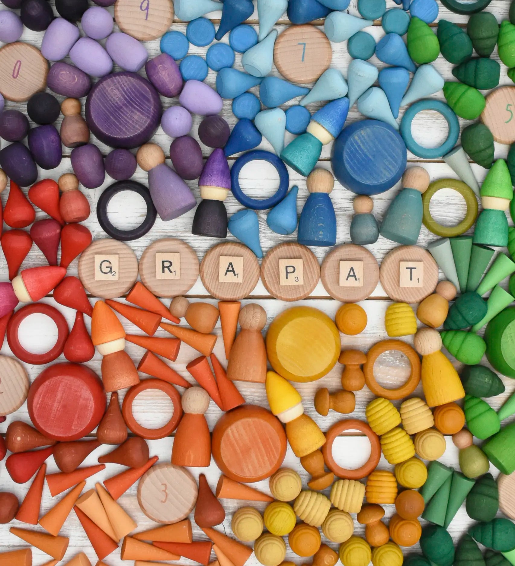 A variety of coloured handcrafted Grapat wooden loose pieces laid in a decorative flatlay