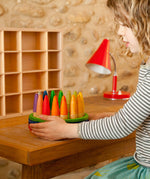 A child playing with the Grapat 18 Palos Stick Men Wooden Peg Dolls. These wooden toys are part of a wide range of open ended toys available at Babipur.  