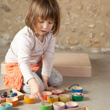 A child playing with the Grapat 12 Rainbow Wooden Sorting Bowls. These Grapat bowls are part of a big range of open ended wooden toys available at Babipur. 