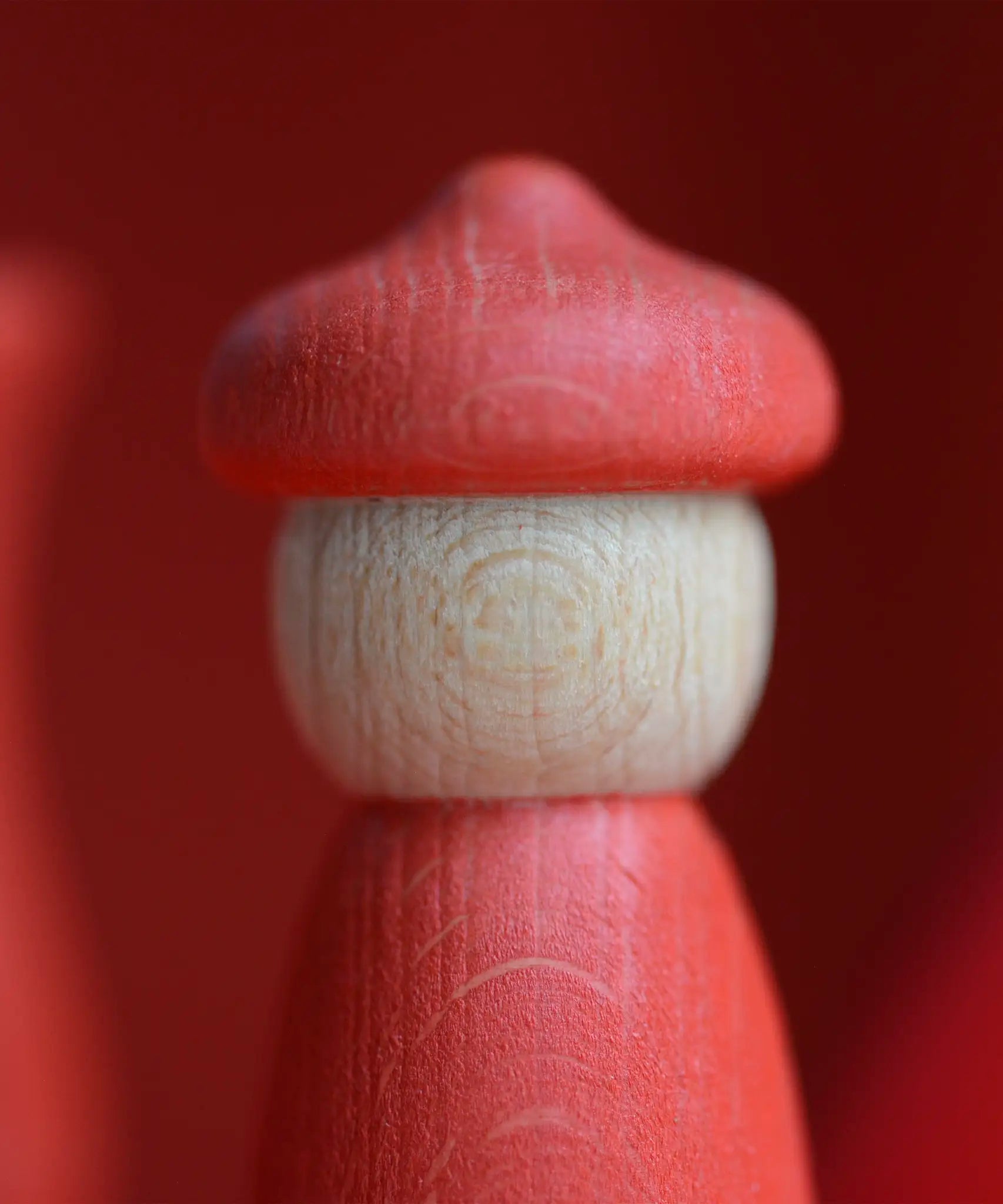 Handcrafted Grapat wooden peg doll in with a red body and matching hat from the 7 moons calendar set