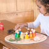 A child placing Nins from the Grapat perpetual calender on the Grapat 4 Seasons and Elements Play Platform. A wooden circle shaped platform and stamped with elements and details to represent the four season. These handcrafted items from Grapat are part of a wide range of wooden toys available here at Babipur.