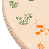 A close up of the green details on the Grapat 4 Seasons and Elements Play Platform. A wooden circle shaped platform and stamped with elements and details to represent the four season. These handcrafted items from Grapat are part of a wide range of wooden toys available here at Babipur.