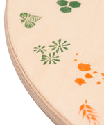 A close up of the green details on the Grapat 4 Seasons and Elements Play Platform. A wooden circle shaped platform and stamped with elements and details to represent the four season. These handcrafted items from Grapat are part of a wide range of wooden toys available here at Babipur.