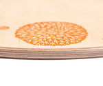 A close up of the orange details on the Grapat 4 Seasons and Elements Play Platform. A wooden circle shaped platform and stamped with elements and details to represent the four season. These handcrafted items from Grapat are part of a wide range of wooden toys available here at Babipur.