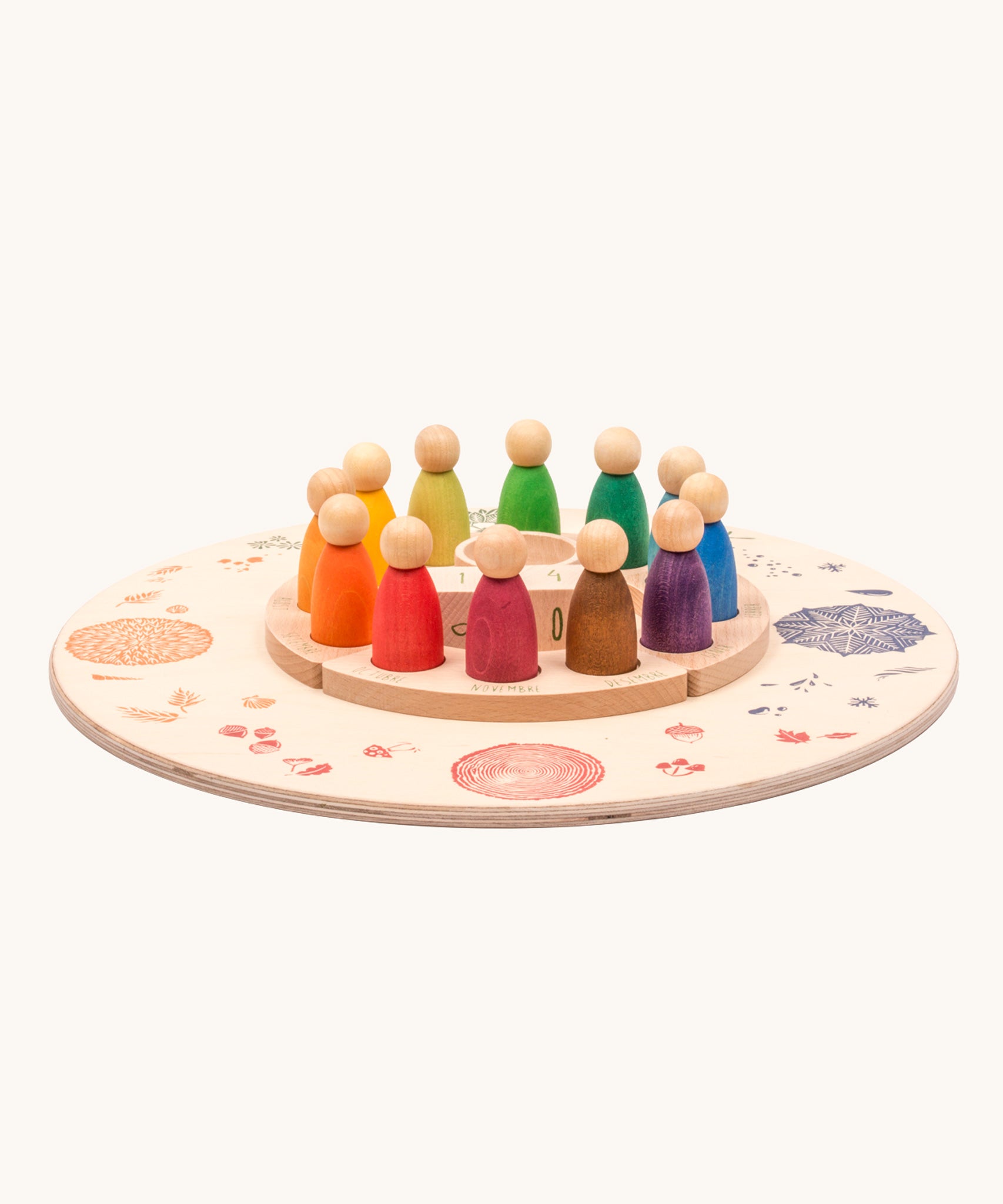 The Grapat Perpetual calendar set placed on the Grapat 4 Seasons and Elements Play Platform. A wooden circle shaped platform and stamped with elements and details to represent the four season. These handcrafted items from Grapat are part of a wide range of wooden toys available here at Babipur.