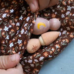 Two wooden Nin figures being held in two hands from the Grapat Moonlight Tale Play Set