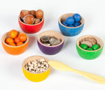 with wooden tweezers. Children sorting marbles and natural loose parts into wooden bowls.