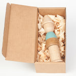 stacked in a human figure form. Made from natural wood and a pastel blue painted section. White background.