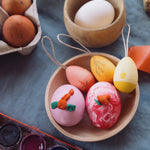 Grapat Handmade Sunrise Eggs Wooden Easter Decorations. The 3 eggs are in a little wooden dish along side real eggs that have been painted.