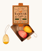Grapat Handmade Sunrise Eggs Wooden Easter Decorations. This set includes 3 warm coloured eggs, in a range of yellows, pink and red with  hand painted floral details. The eggs are show in their cardboard packaging box.