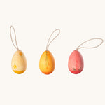 A set of three Grapat Handmade Sunrise Eggs Wooden Easter Decorations. One gg has a two tone natural and yellow painted colour, another has a two toned yellow and orange colour and the other has a pink and deep pink colour. All of the eggs have been hand painted with floral details. 