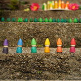 The Grapat set of 6 Rainbow Tomten Figures placed on a step outdoors. Grapat have a wide range of open ended wooden toys and loose parts available at Babipur. 
