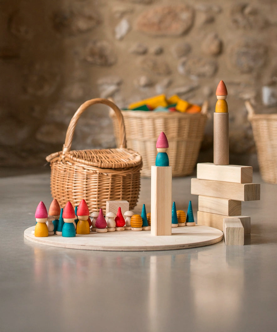 Grapat Tomten Nins wooden peg dolls and loose parts play set placed on a wooden base and blocks. 