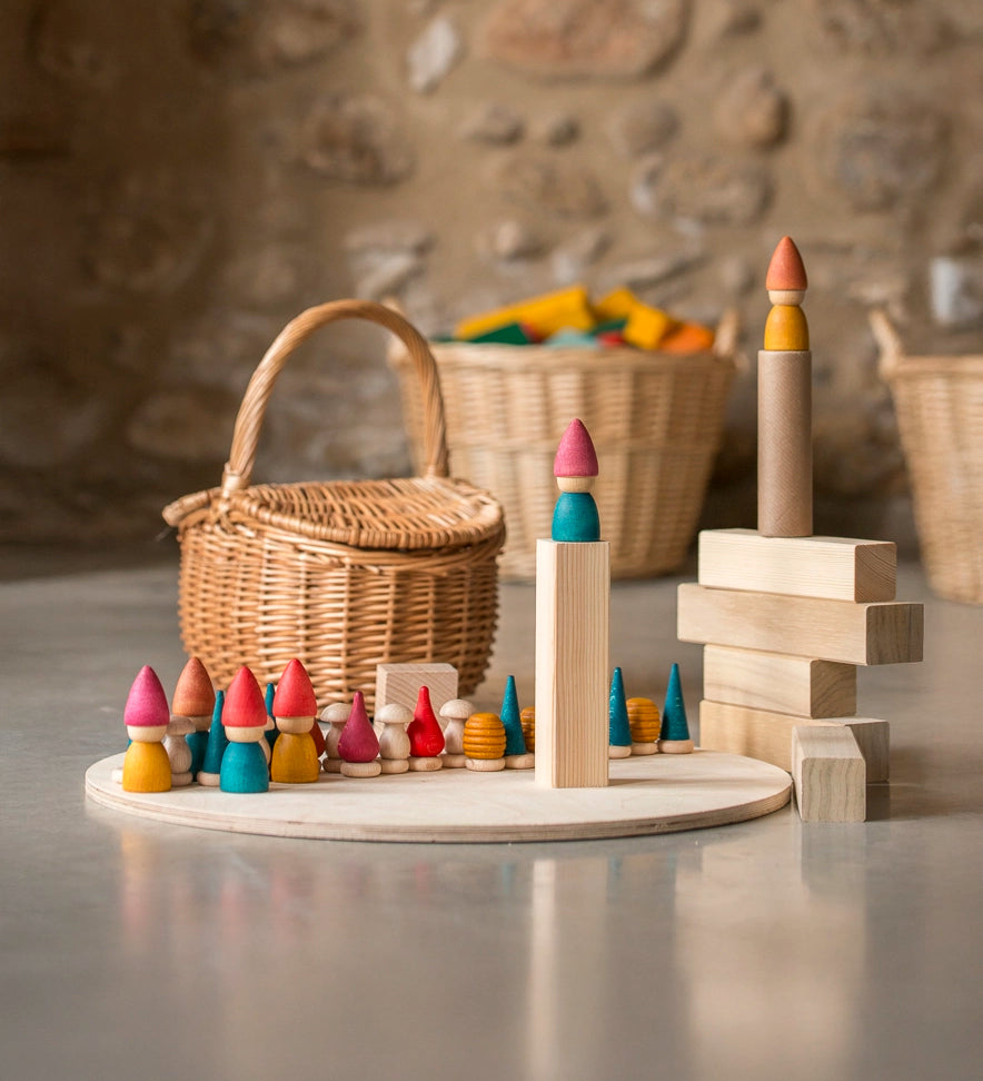 Grapat Tomten Nins wooden peg dolls and loose parts play set placed on a wooden base and blocks. 