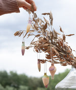 Multicoloured wooden Grapat twinkle decorations hanging on a tree