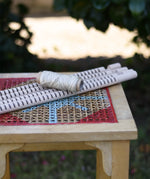 Grapat weaving frame parts placed on a stool outdoors.