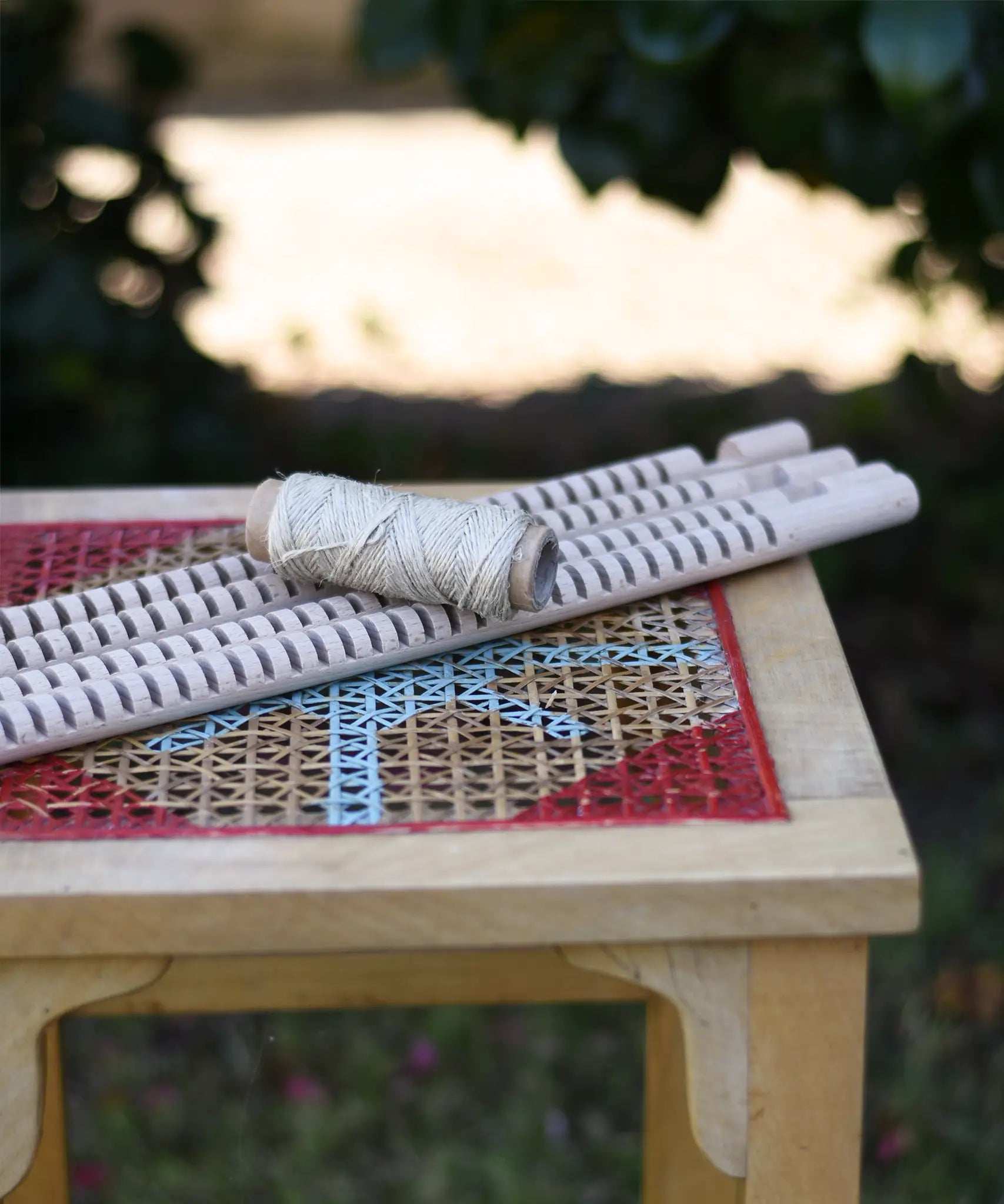 Grapat weaving frame parts placed on a stool outdoors.