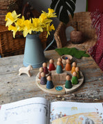 The Grapat Welsh perpetual calendar set up on a wooden surface showing March the 1st as a date. A bunch of daffodils cane be seen just behind it.