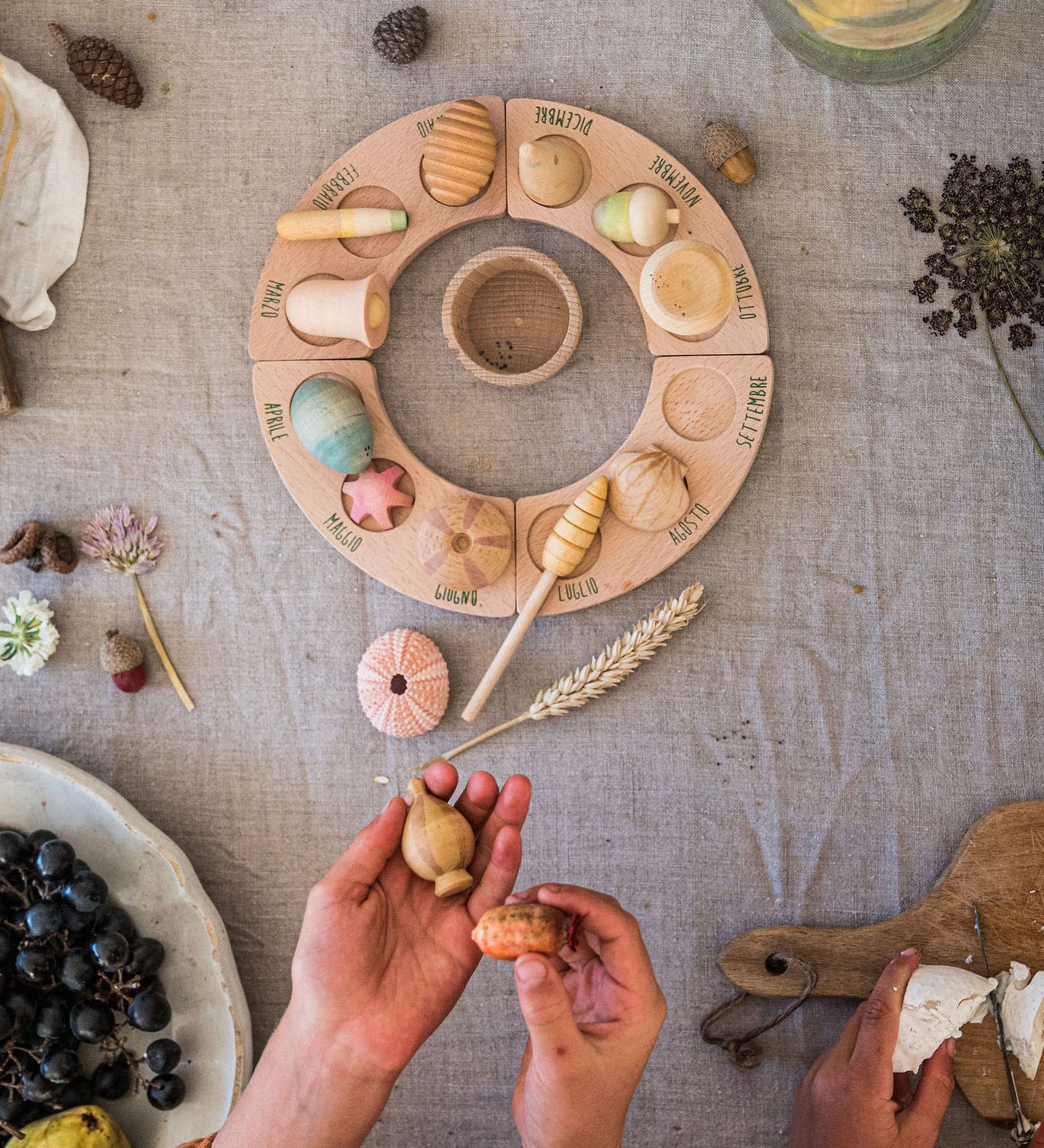 A child placing the pieces from the Grapat Wonders Set on a perpetual calender. A set of 12 wooden toy pieces in various shapes. Grapat have a range of loose parts toys available at Babipur. 