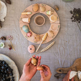 A child placing the pieces from the Grapat Wonders Set on a perpetual calender. A set of 12 wooden toy pieces in various shapes. Grapat have a range of loose parts toys available at Babipur. 