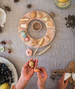 A child placing the pieces from the Grapat Wonders Set on a perpetual calender. A set of 12 wooden toy pieces in various shapes. Grapat have a range of loose parts toys available at Babipur. 