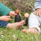 Children playing with Grapat waldorf adult wooden nin peg dolls on grass