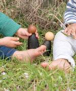 Children playing with Grapat waldorf adult wooden nin peg dolls on grass
