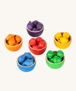 Grapat Wooden Toy Bowls and  Acorns Set. A set of 6 coloured bowls with wooden acorn shapes in matching pieces. These wooden toys are part of a wide range of open ended toys available at Babipur.  