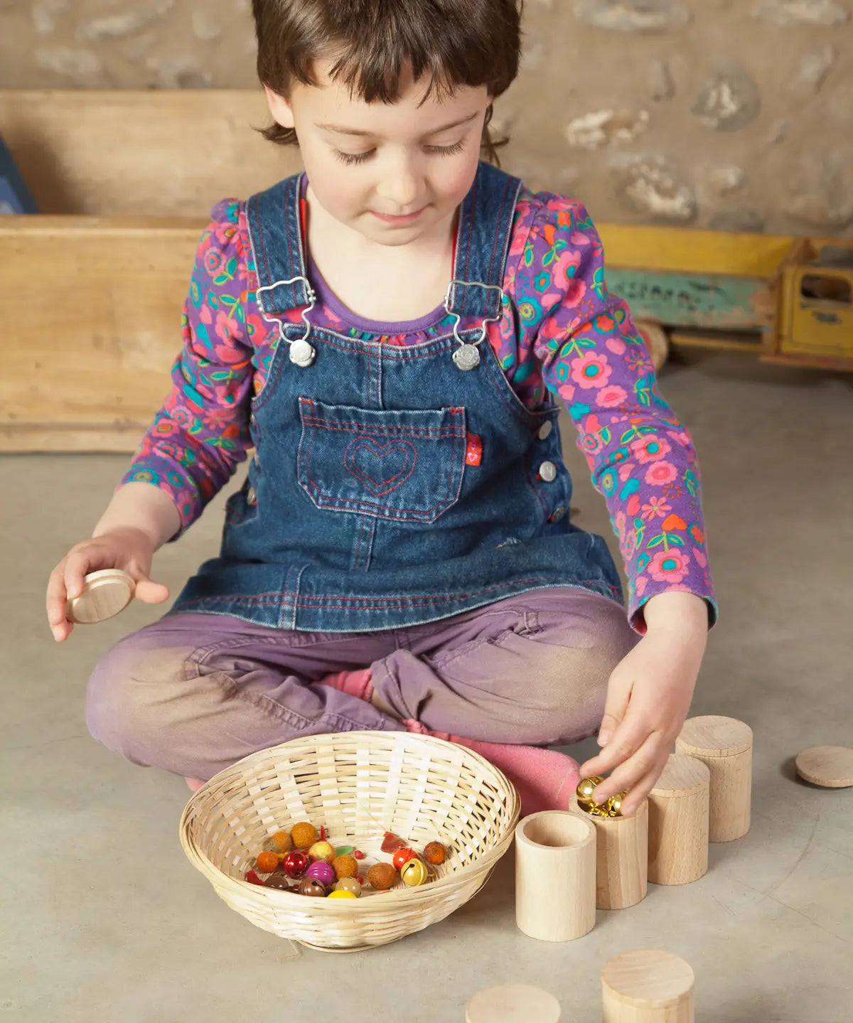 Child sorting loose pieces in the Grapat handcrafted unpainted wooden cups with matching lids