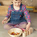 Child sorting loose pieces in the Grapat handcrafted unpainted wooden cups with matching lids