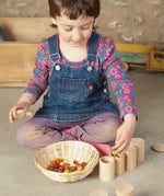 Child sorting loose pieces in the Grapat handcrafted unpainted wooden cups with matching lids