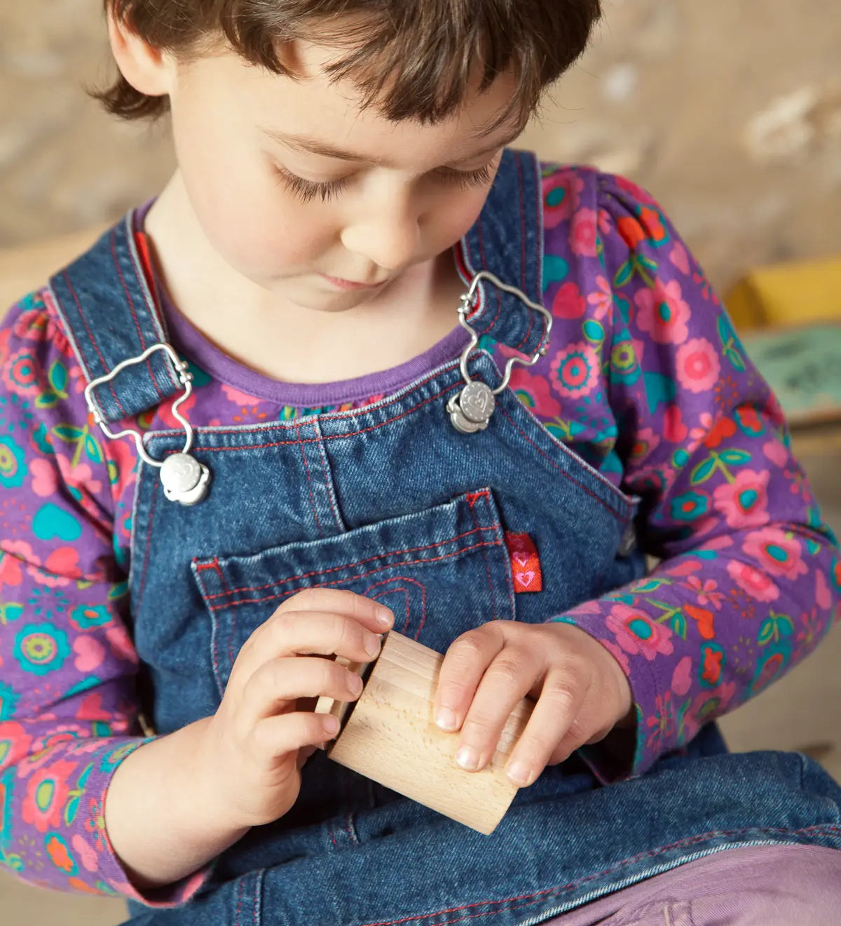 Child holding a Grapat handcrafted unpainted wooden cups with matching lids