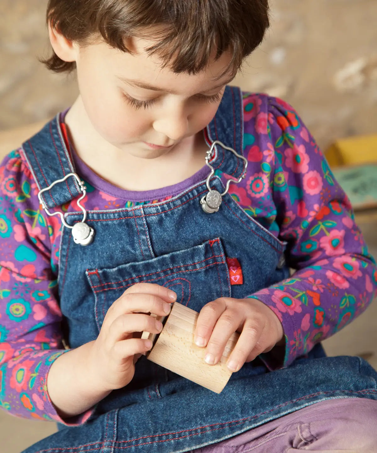 Child holding a Grapat handcrafted unpainted wooden cups with matching lids