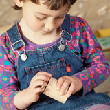 Child holding a Grapat handcrafted unpainted wooden cups with matching lids