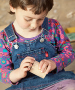 Child holding a Grapat handcrafted unpainted wooden cups with matching lids