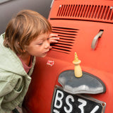 Close up of two children playing with the Grapat handmade fancy nin toy figures on a concrete wall